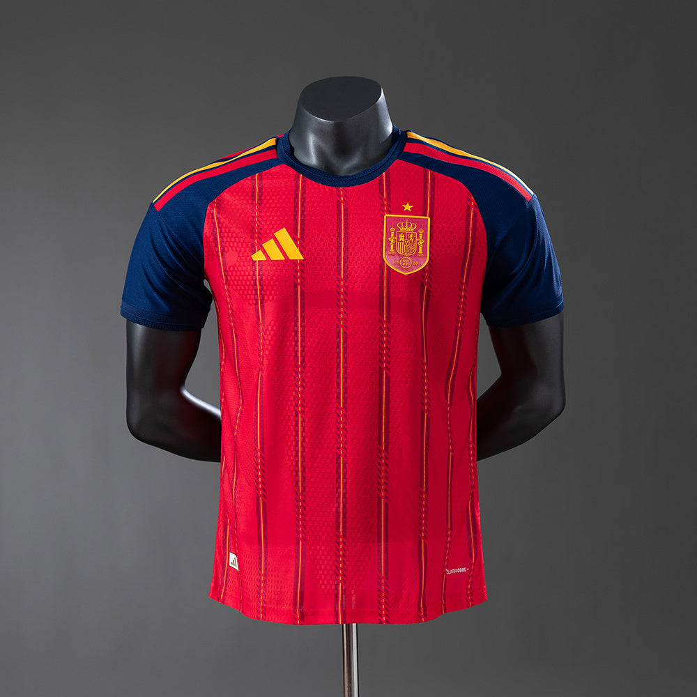 Camiseta España 2026 local en rojo con detalles dorados y escudo bordado.